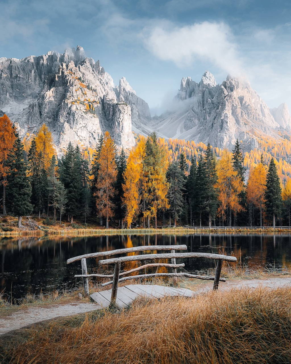 Mountain landscape with lake reflecting snowy peaks and forested shores