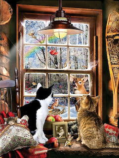 Two cats on a windowsill looking out a window at a snowy winter scene with deer and birds