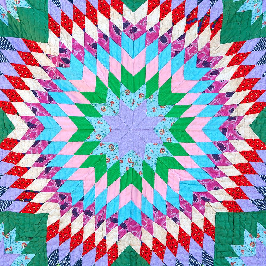 Starburst quilt with radiating chevron pattern in vibrant reds, greens, cyans, pinks, and lavender with small floral motifs