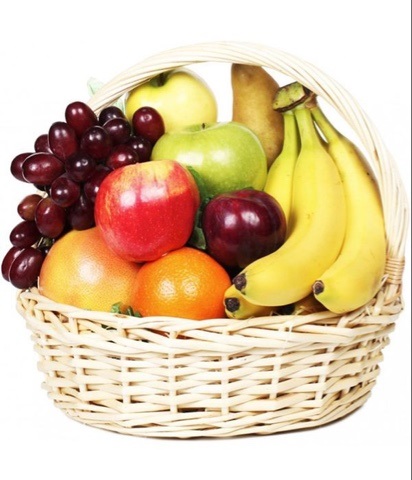 Wicker basket filled with bananas, apples, oranges, pears, and grapes on a white background