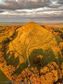 Stone tower of St Michael on grassy Glastonbury Tor hill