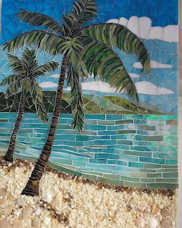 Mosaic art of two palm trees leaning over a turquoise sea with sandy beach in foreground