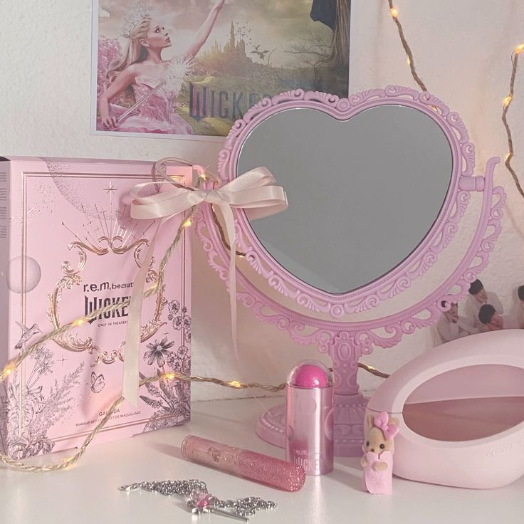 Pink heart-shaped mirror with beauty products and decorative box on vanity