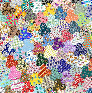 Colorful patchwork quilt with various fabric patterns including florals, dots, stripes and geometric shapes
