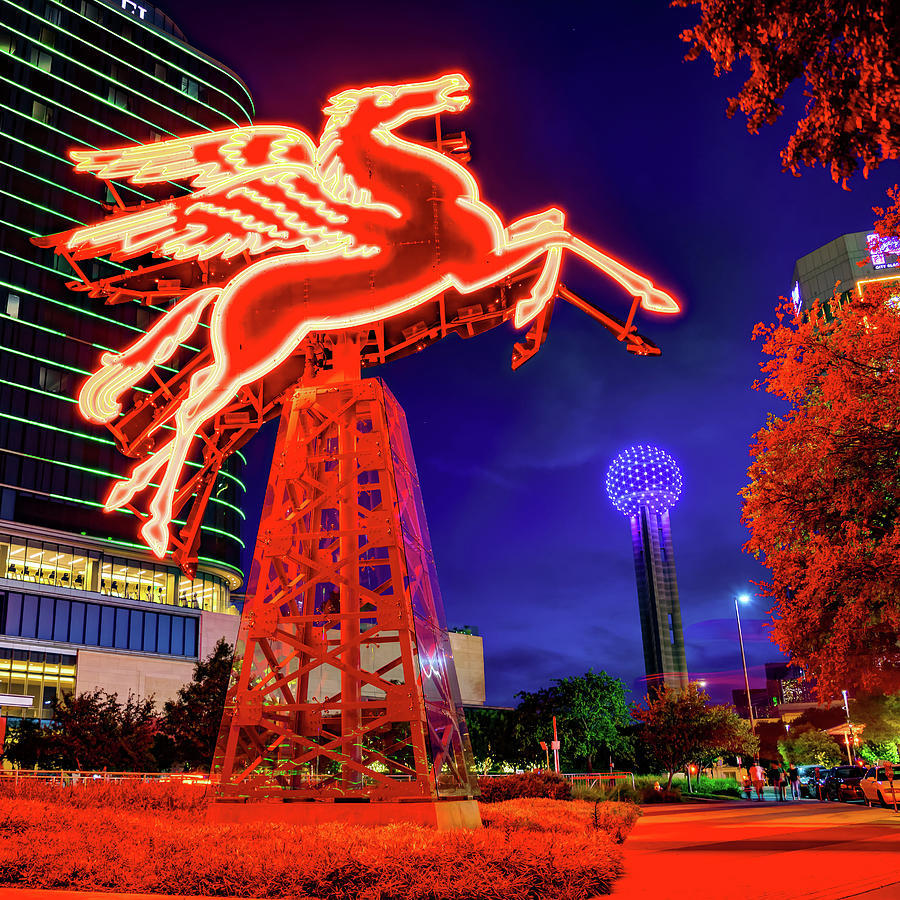 Neon Pegasus sign in downtown Dallas at night with Reunion Tower in the background