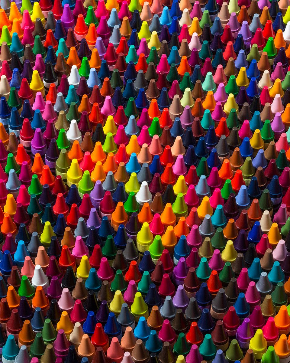 Close-up of many colorful cone-shaped crayons arranged in a dense pattern
