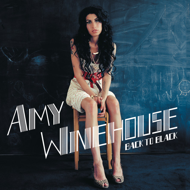 Amy Winehouse seated on a stool against a dark blue wall on the Back to Black album cover