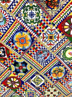 Colorful mosaic wall with geometric patterns, flowers, and decorative ceramic tiles in red, blue, yellow, and green