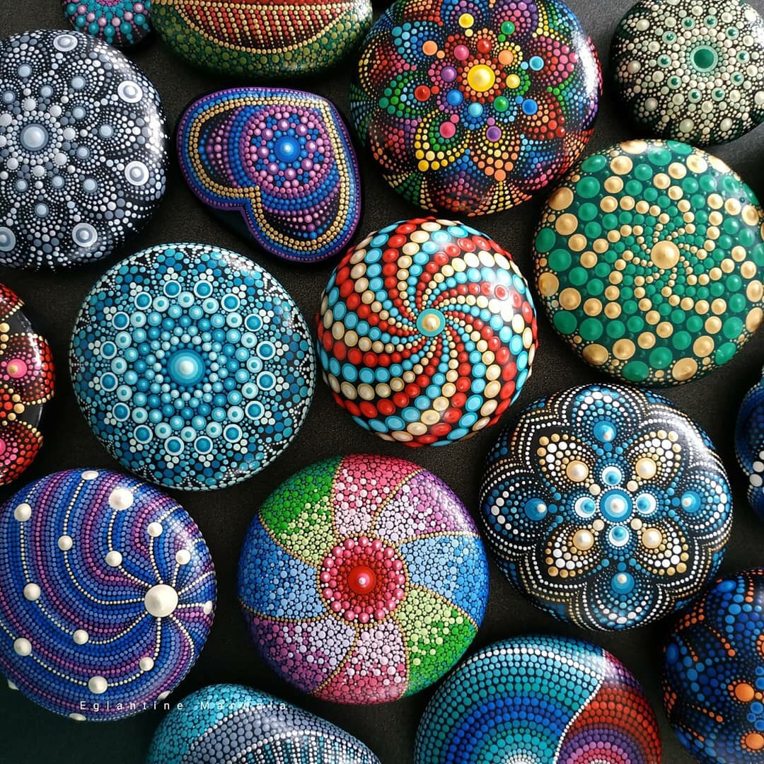 Colorful hand-painted stones with intricate dot mandala patterns in various colors