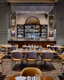 Upscale hotel restaurant with arched bar, velvet dining chairs, and elegant interior design
