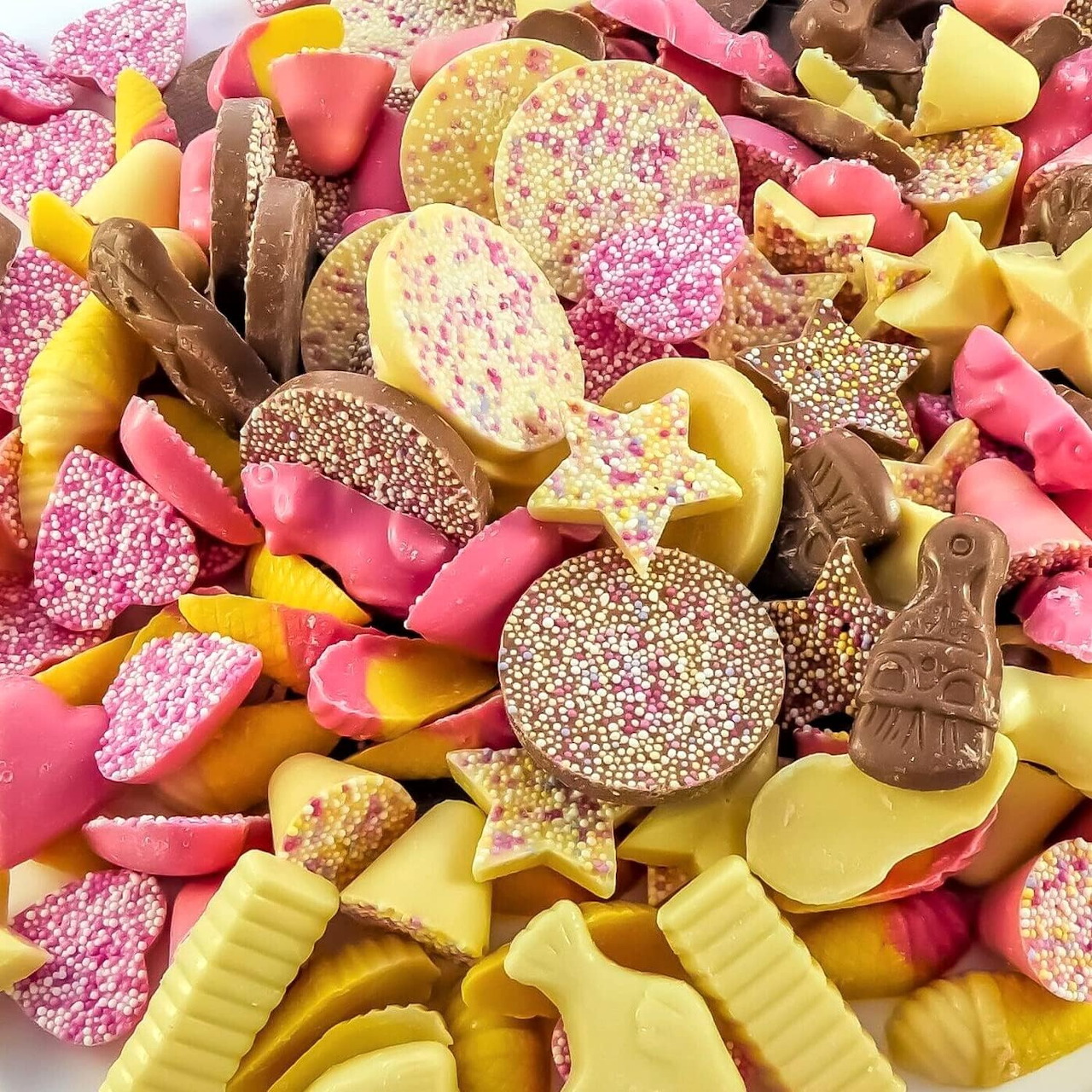 Colorful pile of pick and mix sweets with gummies, chocolates, and sprinkle-covered candy