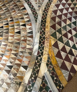 Decorative marble floor with geometric mosaic patterns in earth tones and gold accents