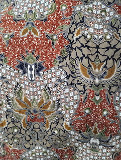 Ornate Moroccan fabric with floral damask patterns in orange, black, gold and white