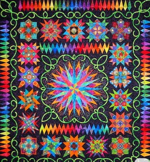 Colorful quilt with central starburst design, geometric floral blocks, and rainbow zigzag borders on black fabric