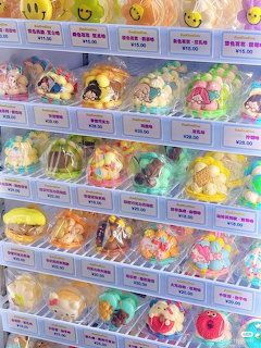 Store display shelves with rows of colorful packaged candy and character-themed sweets in clear boxes
