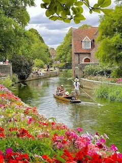 Canal scene with flowers, bridge, and boat in Westgate Gardens Canterbury