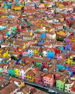 Aerial view of colorful houses in Burano, Venice with bright painted facades and red tile roofs