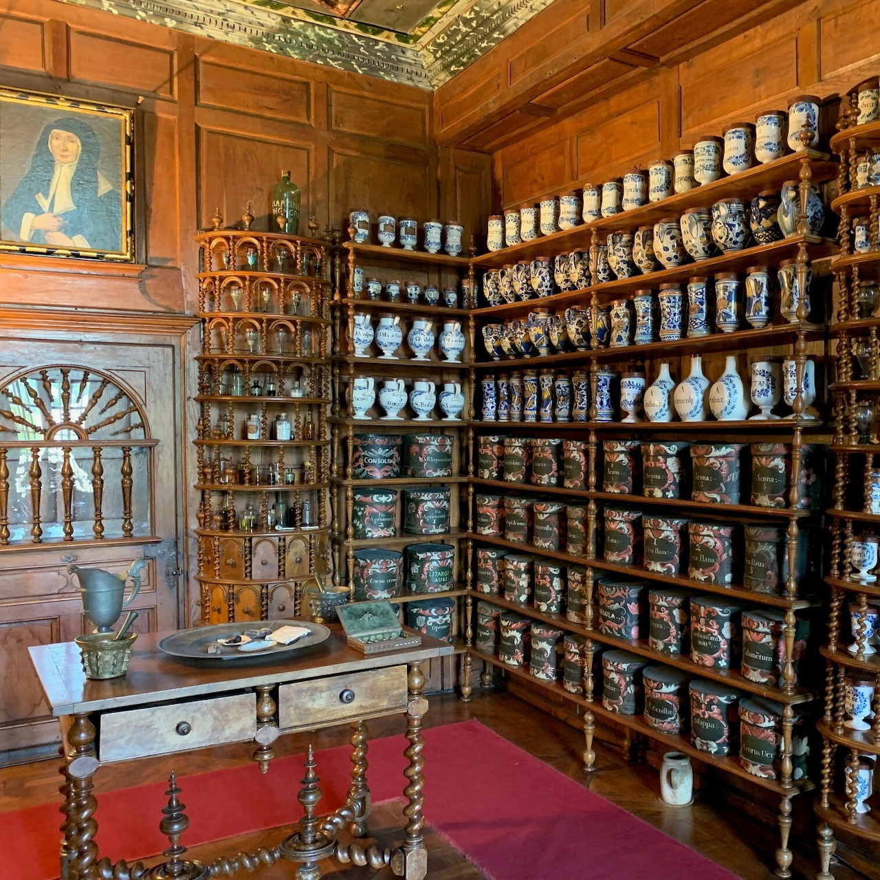 Historic pharmacy room with wooden shelves filled with ceramic apothecary jars