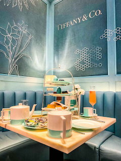 Afternoon tea table at Tiffany Blue Box Cafe with turquoise booth seating and tiered pastry stands