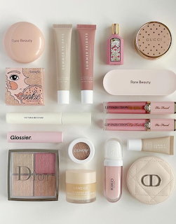 Flat lay arrangement of various makeup and skincare products on white surface