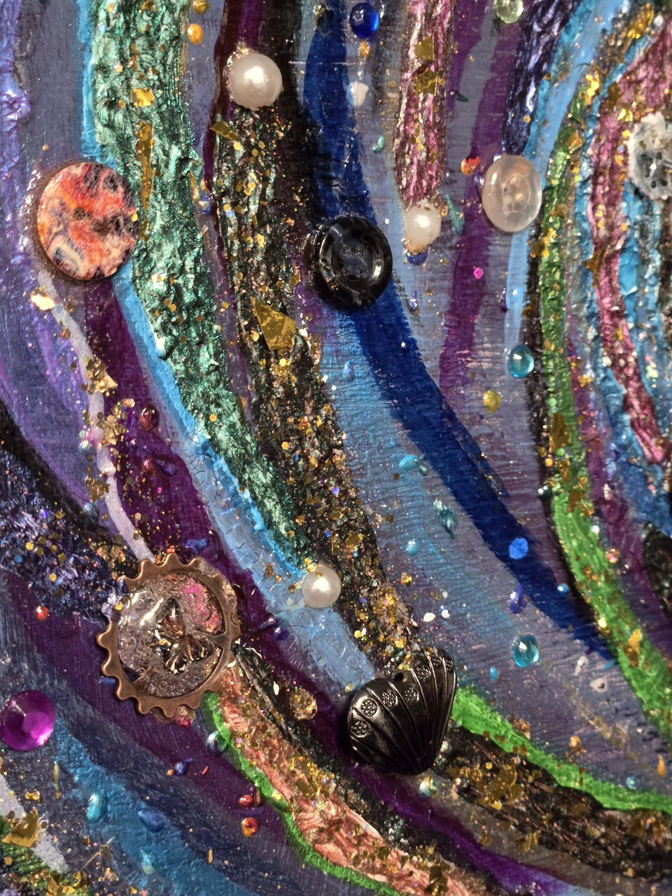 Colorful mixed media art with swirling textured bands of purple, blue, gold and green with pearls and beads