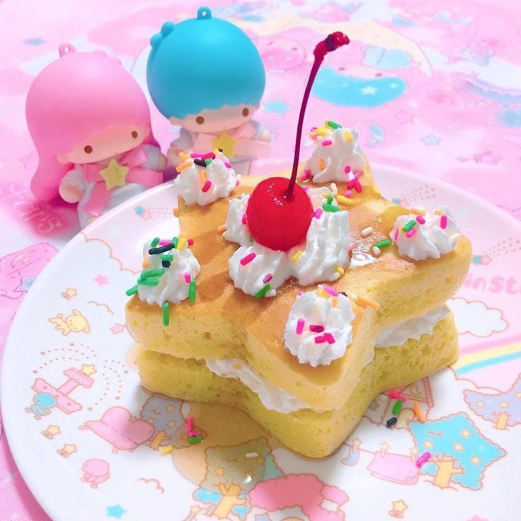 Little Twin Stars characters next to decorated star cake with whipped cream and sprinkles on pastel plate