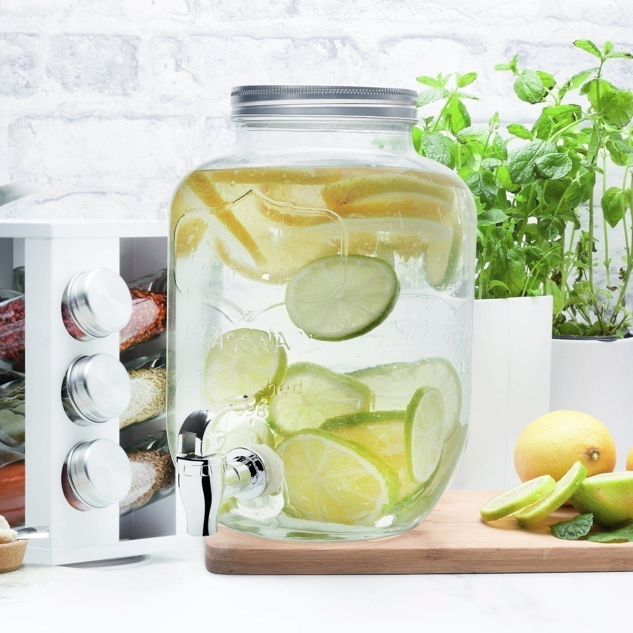 Glass jar of infused water with lemon, lime, and cucumber slices on a kitchen counter