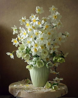 White flower bouquet in a green vase on a lace-covered stool