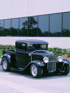 Black 1932 Ford Model B custom pickup truck with chrome accents parked outdoors