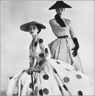 Black-and-white vintage photo of two women in polka dot dresses and wide-brimmed hats