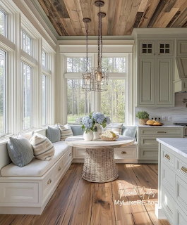 Bright kitchen breakfast nook with white built-in seating, large windows, wood ceiling, and chandelier