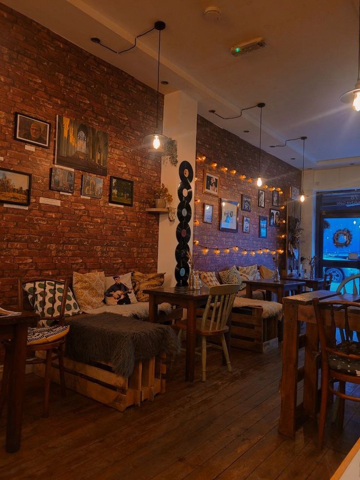 Warm cafe interior with exposed brick walls, wooden furniture, framed pictures, and soft lighting