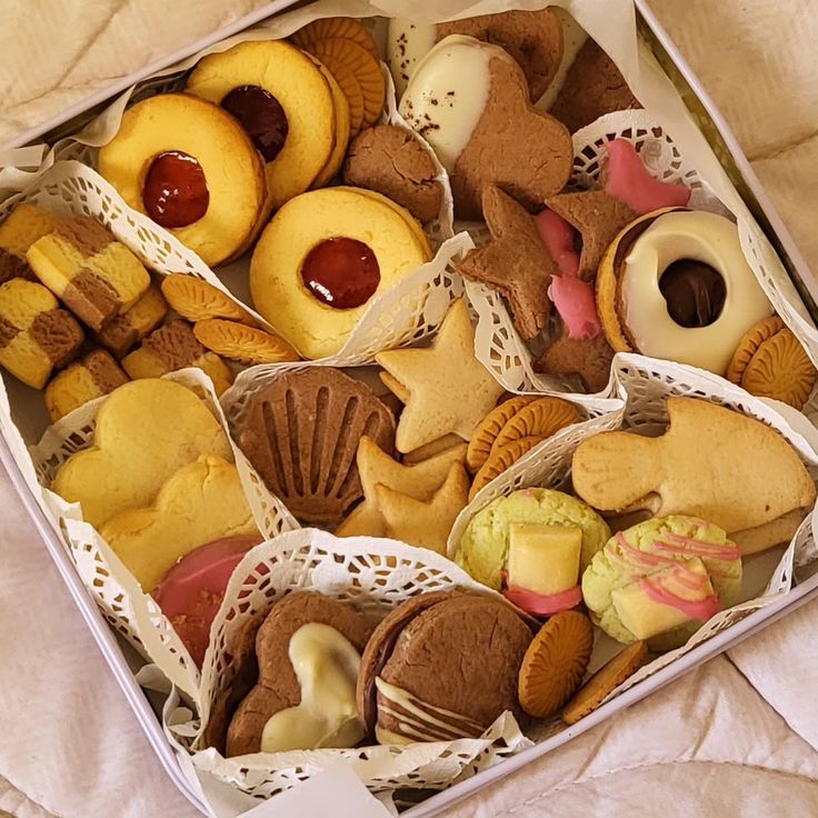 Assorted decorated cookies in a gift box with teddy bears, hearts, and jam-filled varieties