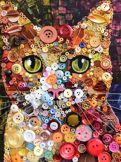 Cat face mosaic made of colorful buttons and beads with green eyes on dark background