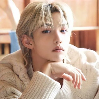 Young man with blonde hair and light sweater in soft-focus portrait