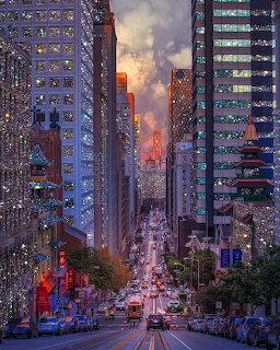 San Francisco city street with cable car tracks leading toward a colorful sunset between tall buildings