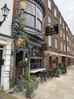 Traditional British pub with curved bay windows and outdoor seating area in Old Portsmouth