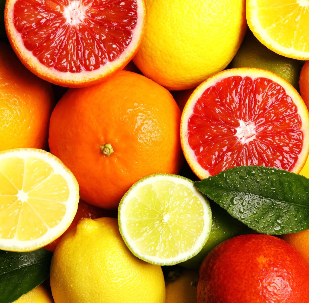 Close-up of lemons, oranges, limes, and halved grapefruits in a colorful arrangement
