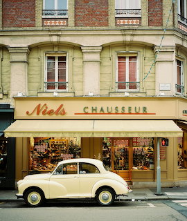 Vintage cream car parked outside Niels Chausseur shoe shop on a French street