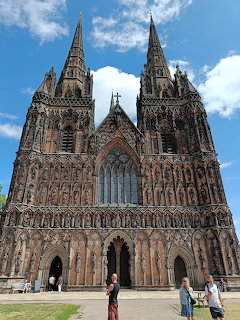 Gothic cathedral facade with two tall spires, ornate stone carvings, and large arched entrance