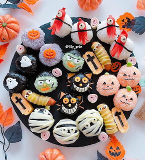 Cute Halloween desserts with smiling faces arranged on black plate with orange pumpkins