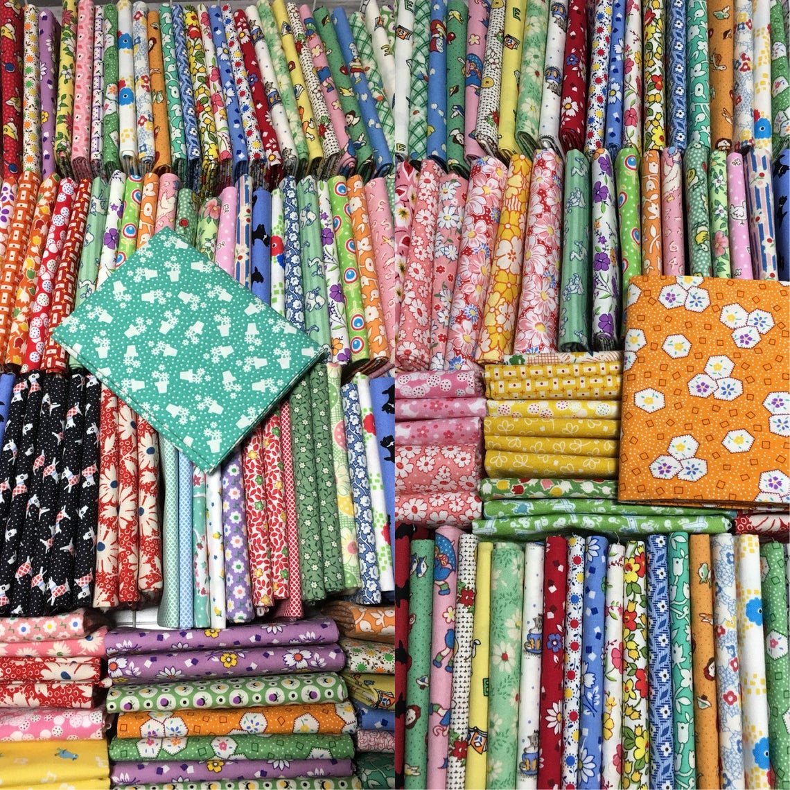 Stacked vintage reproduction fabric fat quarters in various colors and patterns