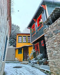 Colorful houses with red shutters in a snowy village alley during winter