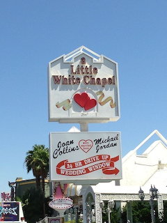 A Little White Chapel sign in Las Vegas with heart decorations and drive-up wedding window advertisement