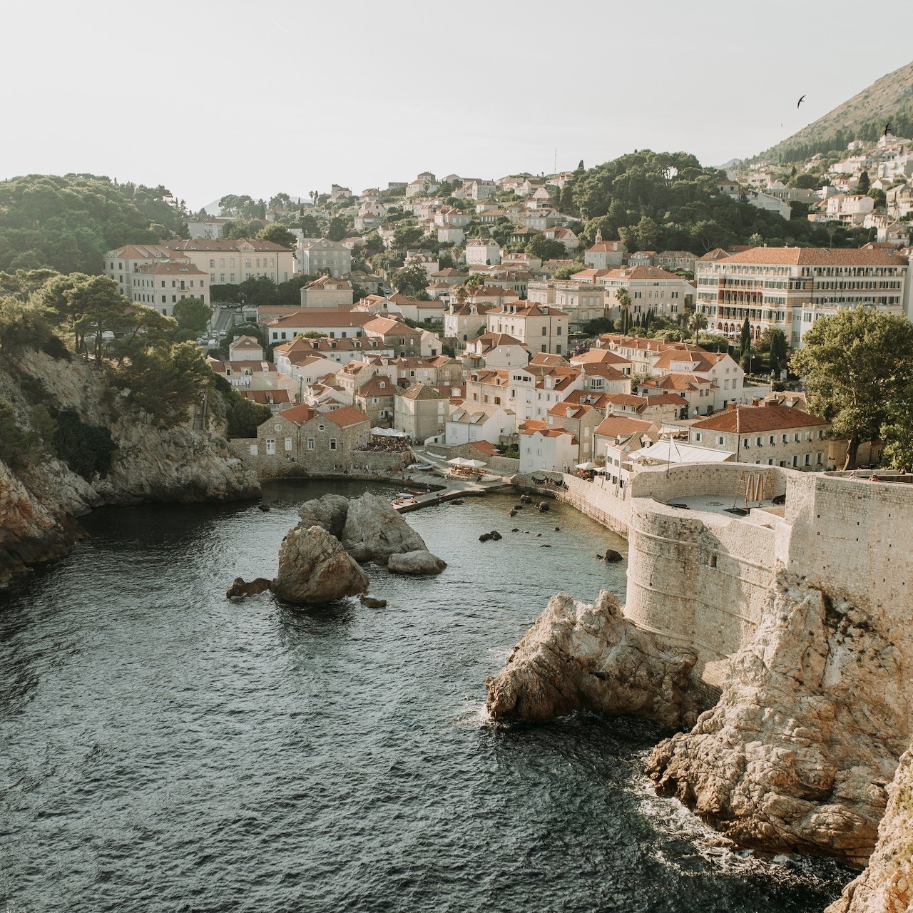 Dubrovnik coastline with old stone walls, red roofs, rocky cliffs, and the Adriatic Sea