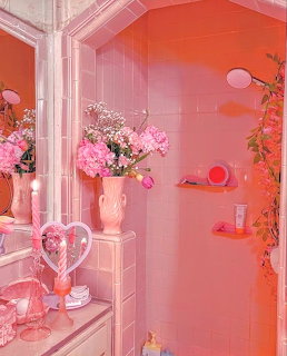 Pink tiled bathroom decorated with flowers, heart mirror, swan vase, and trailing greenery