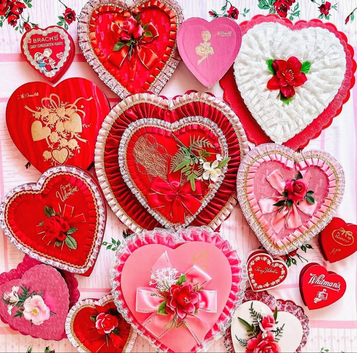Assorted vintage heart-shaped Valentine candy boxes in red and pink with floral decorations and cupid designs