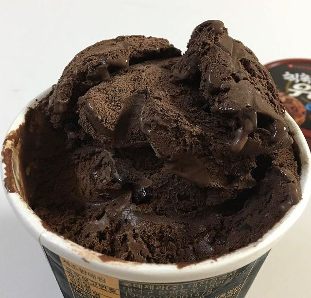 Close-up of chocolate ice cream scoops in a small paper cup