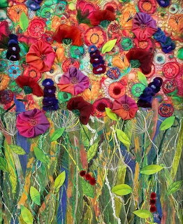 Colorful fabric art quilt showing a garden of flowers with embroidered stems and layered textile blooms in vibrant colors