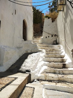 White stone steps leading up a narrow alley between whitewashed buildings in Lindos, Greece